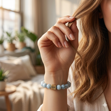Load image into Gallery viewer, Natural aquamarine birthstone bracelet with silver infinity bead worn on wrist against draped white fabric, MysticFlavia lifestyle shot