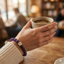 Load image into Gallery viewer, Woman holding coffee cup while wearing MysticFlavia round crystal bracelet with silver bead