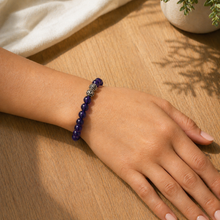 Load image into Gallery viewer, Close-up of hand wearing round amethyst bead bracelet in soft natural sunlight