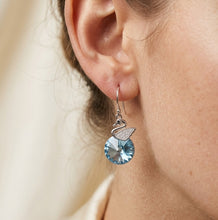 Load image into Gallery viewer, Woman wearing blue crystal swan drop earring, close-up on ear.