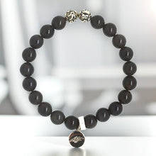 Load image into Gallery viewer, Black obsidian silver bead bracelet 8mm on white surface with engraved silver beads at top and dark brand charm pendant