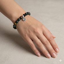 Load image into Gallery viewer, Bloodstone flat silver bead bracelet worn on wrist with silver brand tag visible, MysticFlavia lifestyle shot