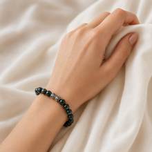 Load image into Gallery viewer, Bloodstone silver bead bracelet worn on wrist against soft white fabric, lifestyle shot