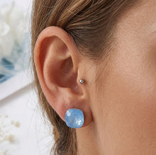 Load image into Gallery viewer, Woman wearing blue Florentine Swarovski crystal stud earring, close-up on ear.