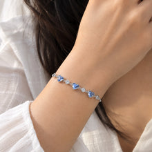 Load image into Gallery viewer, Blue Swarovski crystal heart bracelet worn on a model’s wrist