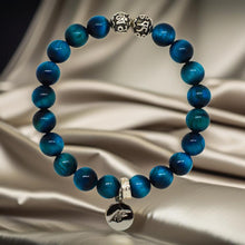 Load image into Gallery viewer, Blue tiger eye silver beads bracelet with silver charm on gold satin fabric