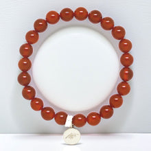 Load image into Gallery viewer, Translucent burnt orange Carnelian bead bracelet with silver pendant charm, white background flat lay