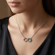 Load image into Gallery viewer, Woman wearing Colorful Infinity crystal silver necklace with infinity pendant on a dark V-neck top