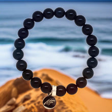 Load image into Gallery viewer, Black tourmaline flat bracelet with silver charm pendant, ocean rock lifestyle shot