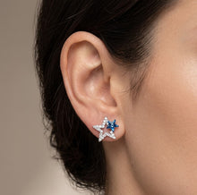 Load image into Gallery viewer, Close-up of dangling star crystal silver earring worn on ear, side angle view.
