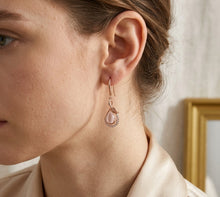 Load image into Gallery viewer, Woman wearing hibiscus stone dangling rose gold earring, close-up on ear.