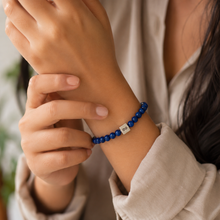 Load image into Gallery viewer, Blue Kyanite Infinity Silver Bracelet 6mm worn on a woman's wrist in a soft lifestyle setting, highlighting the elegant gemstone design.