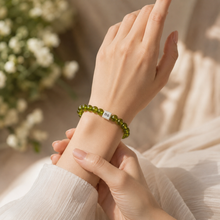 Load image into Gallery viewer, Peridot Stone Infinity Silver Bead Bracelet 8mm worn on a female wrist with 925 Sterling Silver infinity bead | MysticFlavia