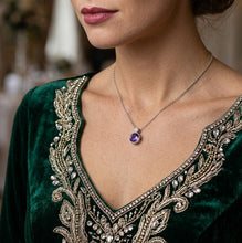 Load image into Gallery viewer, Purple crystal circle pendant silver necklace worn with a dark green velvet V-neck top with gold embroidery