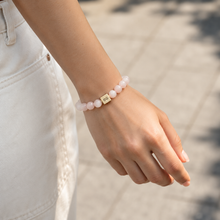 Load image into Gallery viewer, Pink crystal infinity bracelet worn with casual white outfit outdoors