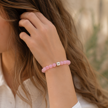 Load image into Gallery viewer, Woman wearing pink rose quartz infinity bead bracelet with casual lifestyle styling