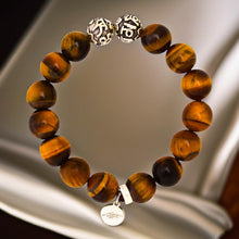 Load image into Gallery viewer, Tiger eye stone silver beads bracelet 12mm with engraved silver charm, styled on grey surface