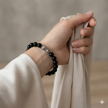 Load image into Gallery viewer, Black tourmaline stone silver beads bracelet worn on wrist with white fabric, close-up shot