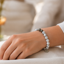 Load image into Gallery viewer, White howlite silver bead bracelet worn on wrist with decorative silver bead and MysticFlavia charm visible