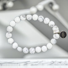 Load image into Gallery viewer, MysticFlavia white howlite bracelet with silver charm, flat lay on dark textured surface