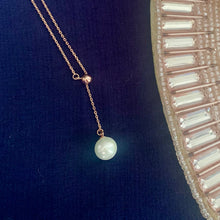 Load image into Gallery viewer, White pearl lariat necklace with silver chain and ring detail on blue background – MysticFlavia
