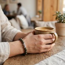 Load image into Gallery viewer, Hand wearing natural pyrite faceted silver beads bracelet while holding coffee cup, cafe lifestyle shot