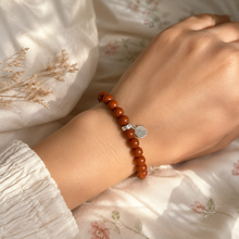Load image into Gallery viewer, Woman wearing Red Jasper Stone Flat Silver Bead Bracelet 8MM by MysticFlavia, showcasing natural red jasper beads and flat sterling silver bead in soft daylight.