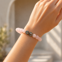 Load image into Gallery viewer, Woman wearing matte rose quartz bracelet with silver designer beads in soft natural lighting