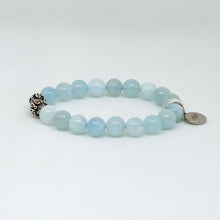 Load image into Gallery viewer, Aquamarine Birthstone round silver bracelet worn on wrist with carved silver beads visible, MysticFlavia indoor lifestyle shot
