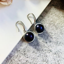 Load image into Gallery viewer, Black natural pearl drop earrings with silver hooks on a textured background
