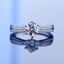 Load image into Gallery viewer, Moissanite ring shown with elegant reflection, featuring a round center stone and pavé side stones