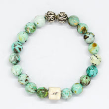 Load image into Gallery viewer, MysticFlavia turquoise bracelet with earthy green-teal marbled beads, two carved silver beads and square brand tag, white background