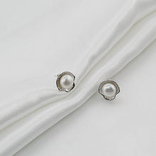 Load image into Gallery viewer, White pearl shell-shaped silver earrings displayed on soft white fabric