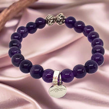 Load image into Gallery viewer, Amethyst round bead bracelet with 925 sterling silver charm displayed on soft satin fabric
