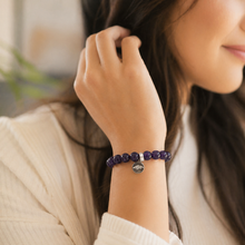 Load image into Gallery viewer, Woman wearing purple amethyst stone bracelet with silver charm and round beads
