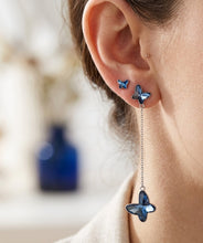 Load image into Gallery viewer, Woman wearing blue butterfly Swarovski crystal drop earring, close-up on ear.
