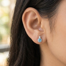Load image into Gallery viewer, Blue Crystal Circle Silver Earrings worn on a model’s ear

