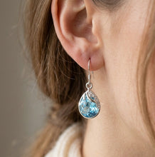 Load image into Gallery viewer, Blue drop crystal silver earrings worn on a model’s ear
