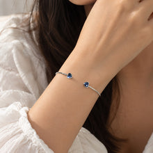 Load image into Gallery viewer, Swarovski crystal open silver bracelet with blue heart-shaped stones on wrist
