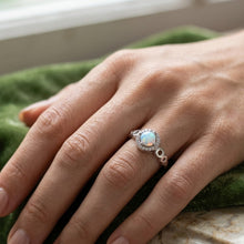 Load image into Gallery viewer, Blue opal ring worn on a finger with an elegant round gemstone and silver band
