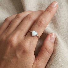 Load image into Gallery viewer, Heart silver ring worn on a woman's finger, showcasing the pale blue opal heart and delicate silver band
