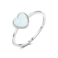Heart silver ring with pale blue opal center and sleek 925 sterling silver band on white background