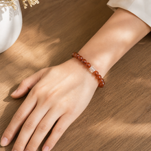 Load image into Gallery viewer, MysticFlavia deep red Carnelian wristband with double silver accent beads, worn on female wrist over wooden table
