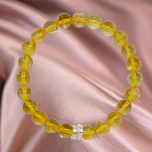 Load image into Gallery viewer, Citrine bracelet displayed on soft pink fabric with warm yellow gemstone beads and silver detail
