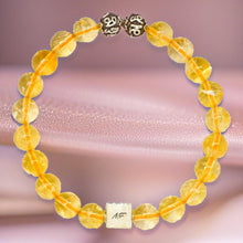 Load image into Gallery viewer, Citrine bracelet displayed on a soft pink fabric backdrop with natural citrine beads and silver details
