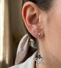 Load image into Gallery viewer, Woman wearing dangling star crystal silver earring, close-up on ear.
