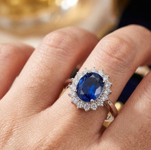 Load image into Gallery viewer, Blue gemstone silver ring with American diamond halo worn on a woman's finger
