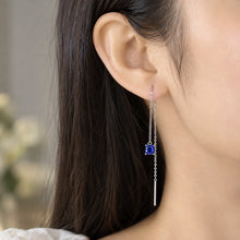Load image into Gallery viewer, Sapphire blue thread earring worn on a model ear, highlighting the long thread chain design
