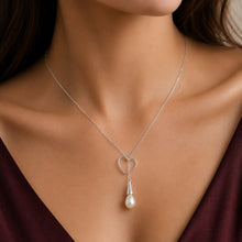 Load image into Gallery viewer, Silver heart pendant necklace with elegant pearl drop on a model
