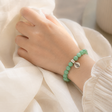 Load image into Gallery viewer, Person wearing MysticFlavia Jade bracelet with silver charm on wrist
